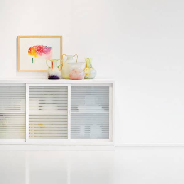Sideboard „Multimodus 6280-U1“ aus massiver Pinie, weiß lasiert. Mit drei Schiebetüren und Türfüllungen aus Klarglas mit satinierten Streifen.